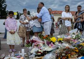 People mourn near floral tributes placed for victims and survivors of a deadly mass shooting during a Jewish Hanukkah celebration at Bondi Beach on December 14, in Sydney